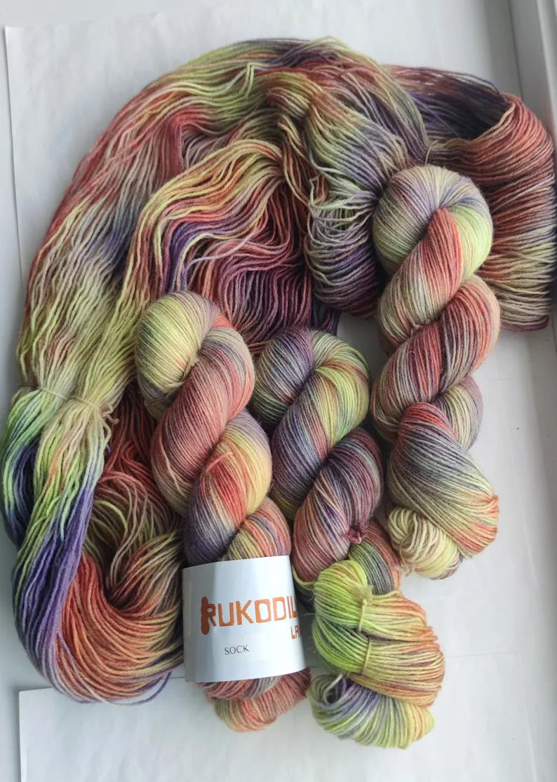 Hand dyed sock yarn in grape purple, lavender, blush pink, olive green and golden tones inspired by autumn vineyards.
