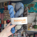 Hand dyed sock yarn set with blue gray variegated skein and two coordinating mini skeins in smoky gray and denim blue tones for knitting socks and shawls.