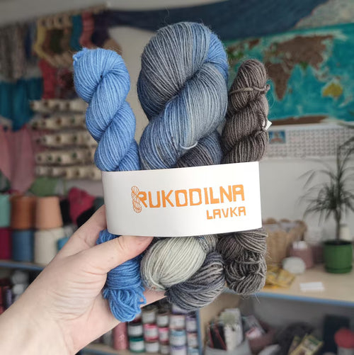 Hand dyed sock yarn set with blue gray variegated skein and two coordinating mini skeins in smoky gray and denim blue tones for knitting socks and shawls.