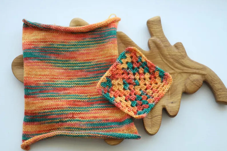 Hand dyed sock yarn in coral, peach, orange, golden yellow and teal green shades, variegated wool nylon yarn inspired by a summer rose garden.