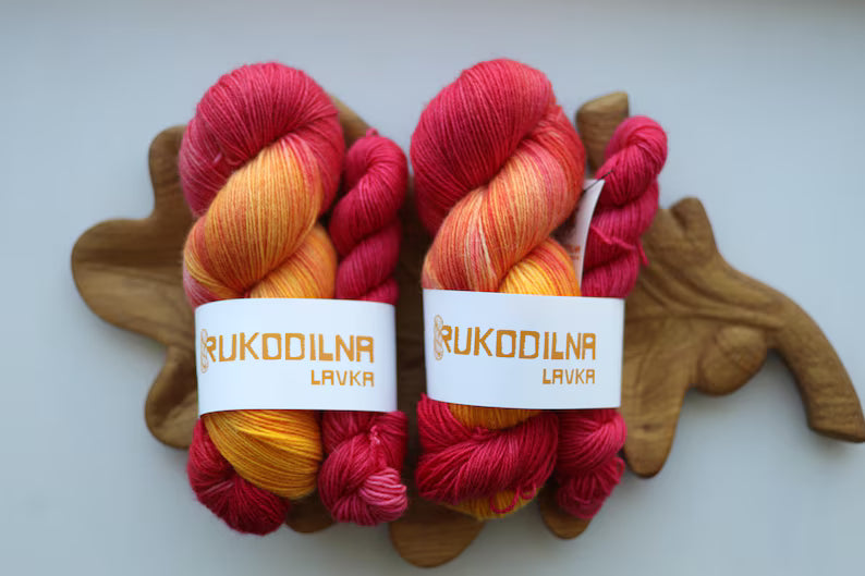 Hand-dyed sock yarn set with one 100g skein and one 20g mini in sunset shades of golden yellow, orange and raspberry red.