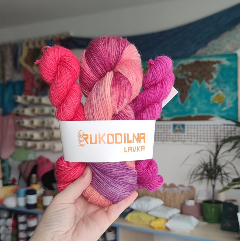Hand dyed pink sock yarn set with one variegated skein and two matching mini skeins in shades of raspberry, blush pink, and orchid.