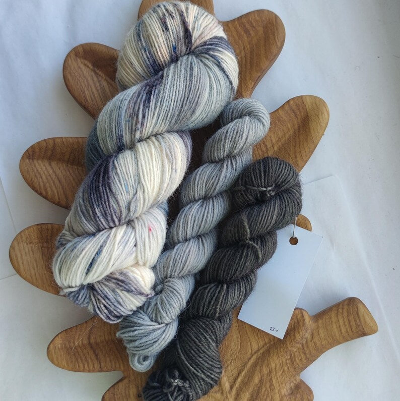 Hand dyed sock yarn set with full skein and two mini skeins in silver grey, charcoal and black shades, fingering weight wool nylon yarn for sock knitting projects.
