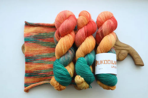 Hand dyed sock yarn in coral, peach, orange, golden yellow and teal green shades, variegated wool nylon yarn inspired by a summer rose garden.