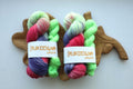 Hand dyed sock yarn set featuring vibrant purple, pink and lime green shades paired with a coordinating contrast mini skein. Perfect for colorful socks, shawls and accessories.