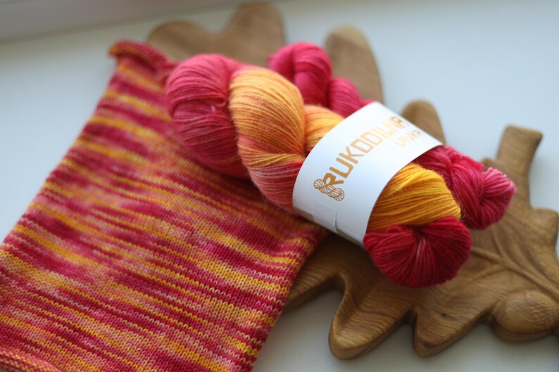Hand-dyed sock yarn set with one 100g skein and one 20g mini in sunset shades of golden yellow, orange and raspberry red.