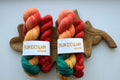 Hand dyed sock yarn set with matching mini skein in coral, green, red, and yellow, 100g + 20g fingering weight wool nylon knitting yarn for socks.