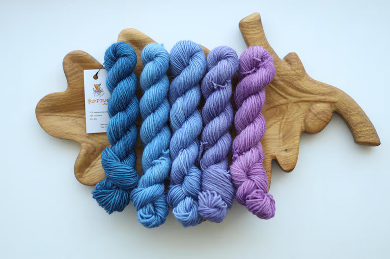 Hand dyed mini skein set with five blue and purple fingering weight sock yarn mini skeins for knitting and crochet colorwork.