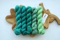 Hand dyed green mini skein set with five fingering weight sock yarn mini skeins in teal, forest green and mint shades for knitting and crochet.