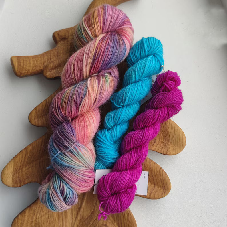 Hand-dyed sock yarn set with two mini skeins in turquoise and fuchsia, pastel pink, peach, lavender, and mint fingering weight wool nylon yarn for knitting colorful socks.