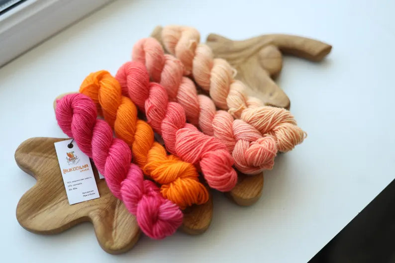 Hand dyed mini skein set with five coordinating sock yarn minis in pink, coral, peach and cream shades for fade knitting and colorwork projects.