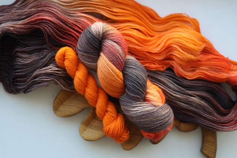 Hand dyed fall sock yarn set with a variegated taupe and rust skein paired with a bright pumpkin orange mini skein for knitting socks.