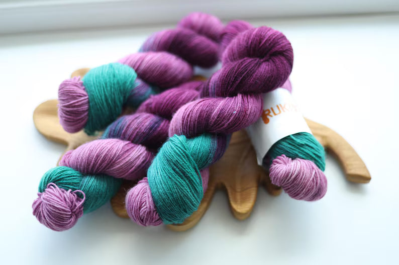 Purple and green hand dyed sock yarn with lavender shades, 4-ply fingering weight yarn for knitting socks.