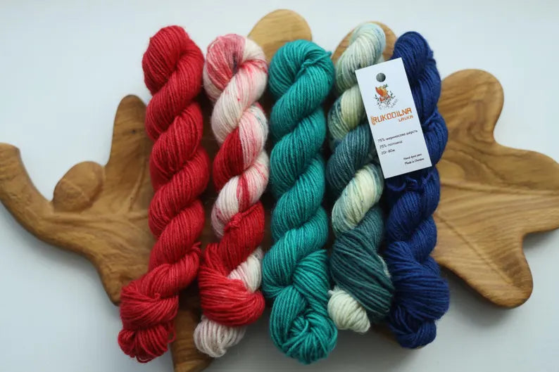 Hand dyed Christmas mini skein set with five festive sock yarn minis in red, candy cane, teal, evergreen and deep blue.