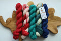 Hand dyed Christmas mini skein set with five festive sock yarn minis in red, candy cane, teal, evergreen and deep blue.