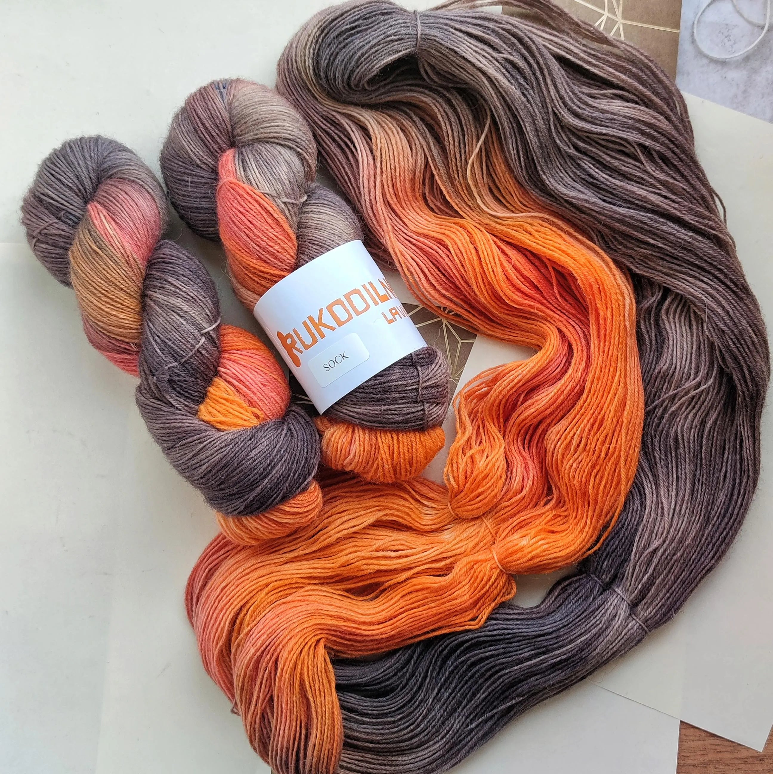 Hand dyed variegated sock yarn in smoky grey, charcoal, coral and bright orange shades, superwash wool nylon fingering weight 4 ply yarn for knitting socks shawls and sweaters