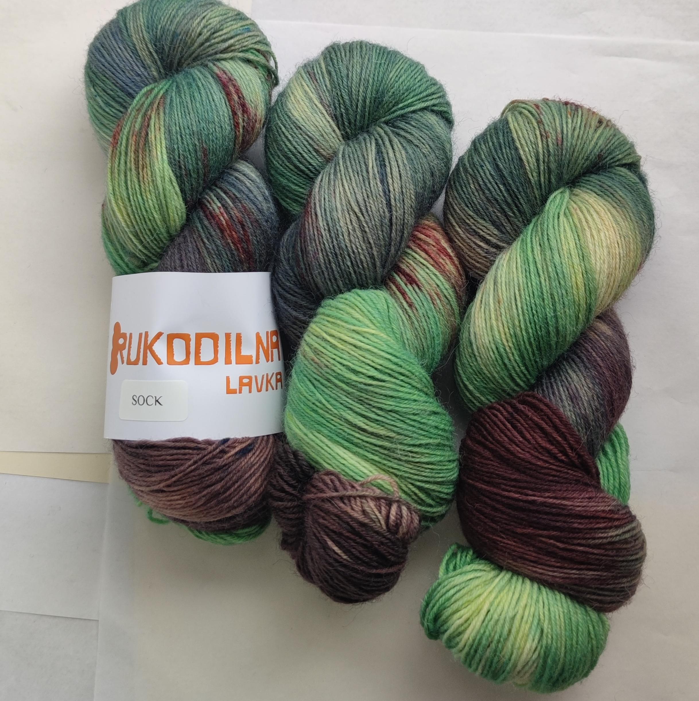 Hand dyed forest green sock yarn with earthy brown and moss tones inspired by mountain landscapes and nature.