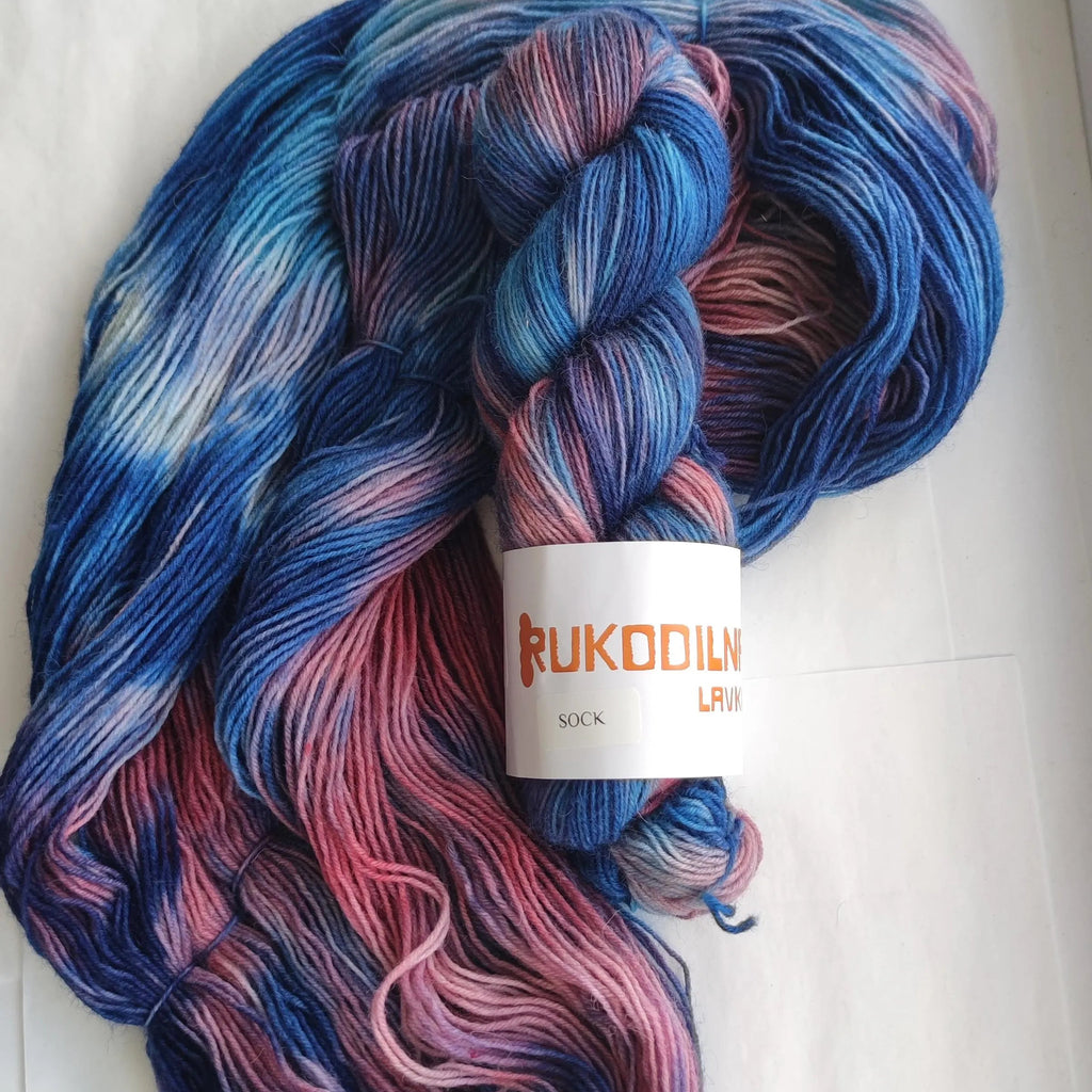 Hand dyed sock yarn in electric blue, raspberry red, icy pink and deep cobalt tones on superwash wool nylon fingering weight base.