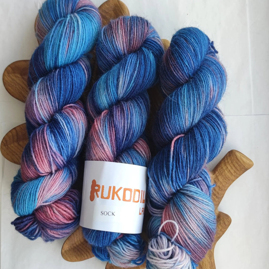 Hand dyed sock yarn in electric blue, raspberry red, icy pink and deep cobalt tones on superwash wool nylon fingering weight base.