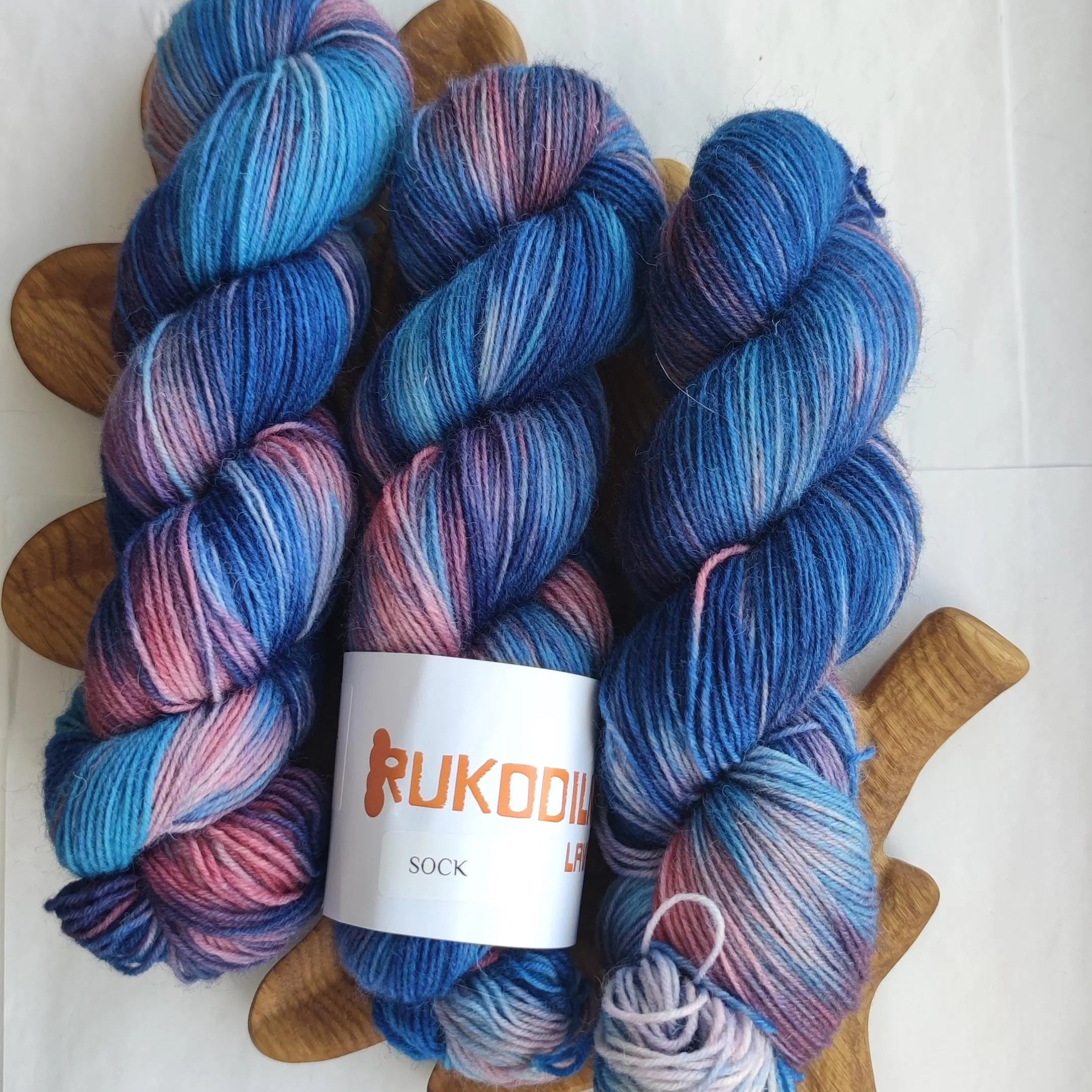 Hand dyed sock yarn in electric blue, raspberry red, icy pink and deep cobalt tones on superwash wool nylon fingering weight base.